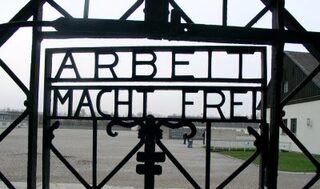 Tor des Konzentrationslagers Dachau mit dem Schriftzug "Arbeit macht frei"