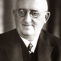 Das Bild zeigt den ehemaligen Bürgermeister Josef Kleinsorg mit rundlicher Brille und Anzug mit Krawatte.