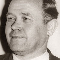 Das Bild zeigt den ehemaligen Bürgermeister Johann Schmitz mit Anzug und Krawatte.