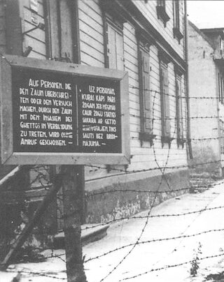Zaun mit Warnschild vor dem Ghetto Riga